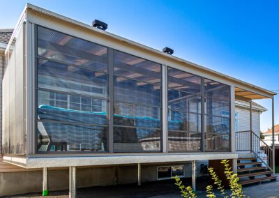 Fermeture d'un solarium avec des fenêtres de vinyle et moustiquaires