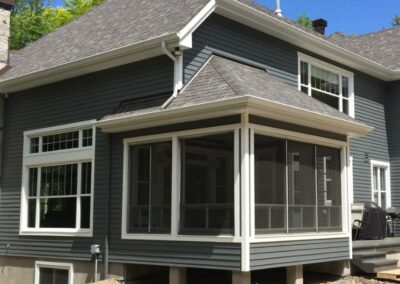 Fermeture d'un patio couvert avec fenêtres et moustiquaires